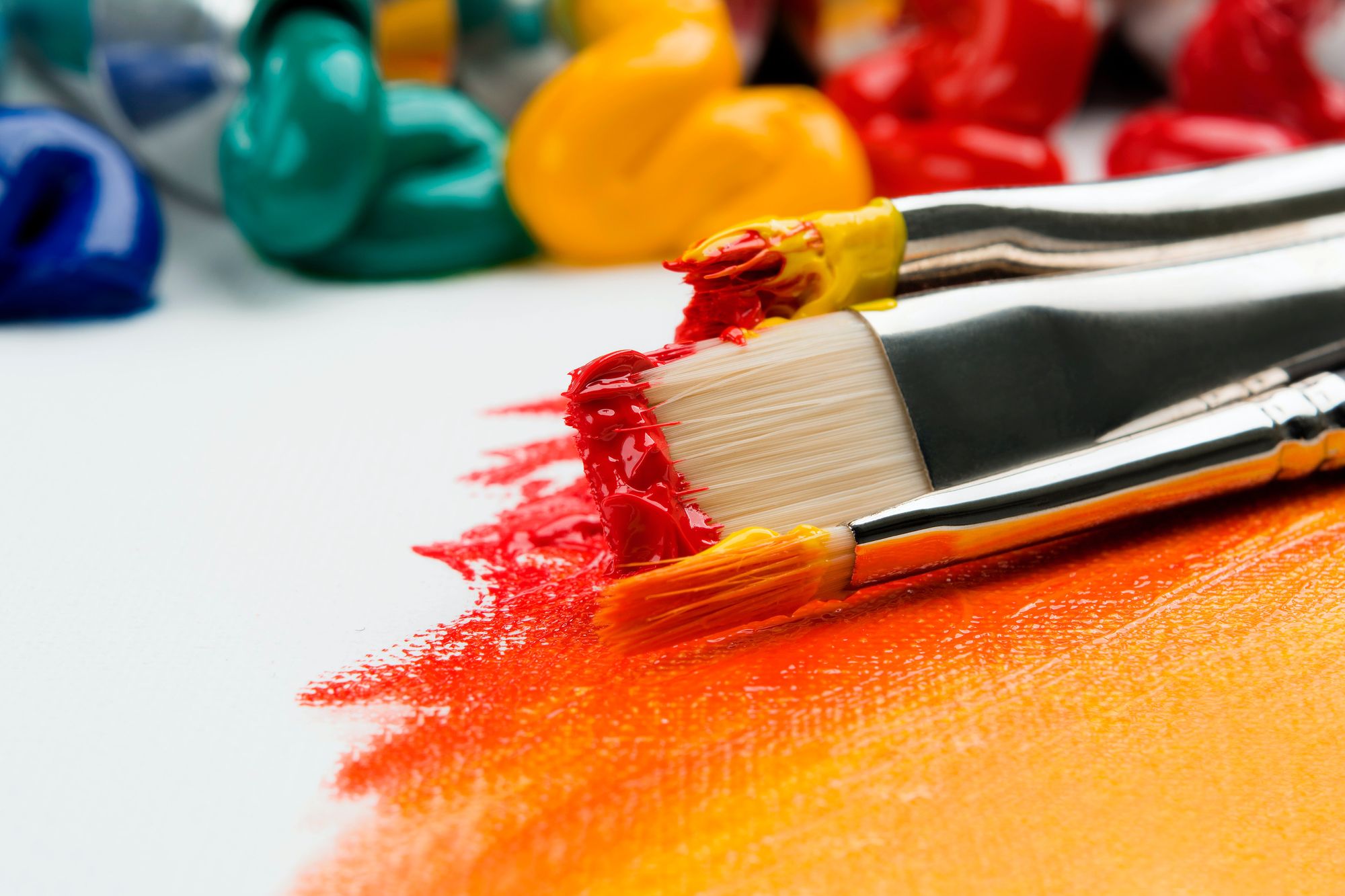 Artist paint brushes on wooden palette. Texture mixed oil paints